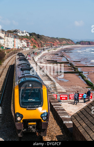 Cross Country Voyager Zug entlang Dawlish Ufermauer mit den Reparaturen an beschädigten Wand im Hintergrund Stockfoto