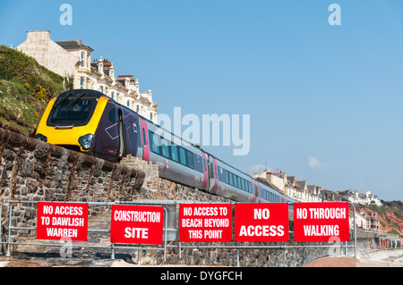 Cross Country-express-Zug vorbei entlang Dawlish Sea Wall vorbei die Warnzeichen, die Verhinderung des Zugriffs auf die beschädigte Deich Stockfoto