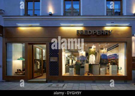 Fred Perry, München, München, Deutschland. Architekt: BuckleyGrayYeoman, 2012. Äußere vordere Ansicht in der Abenddämmerung. Stockfoto