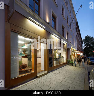 Fred Perry, München, München, Deutschland. Architekt: BuckleyGrayYeoman, 2012. Perspektive der Vorderansicht in der Abenddämmerung. Stockfoto