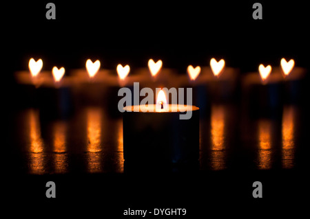 Kerzen mit aus Fokus Flammen in Form von Liebe Herzen, Valentinstag Stockfoto