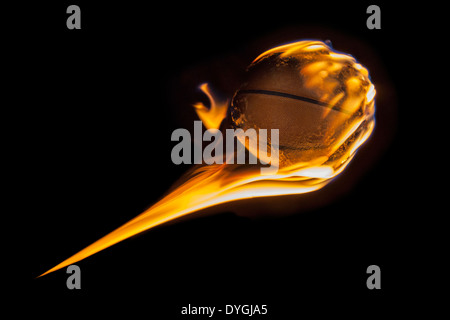 Flammende Basketball in Dunkelheit fliegen. Stockfoto