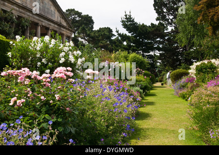 Ein Gärtner tendenziell die bunten Staudenrabatten in Kiftsgate Court in den Cotswolds, Gloucestershire, England Stockfoto