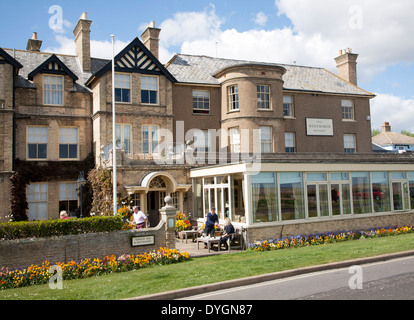Menschen sitzen vor dem Wentworth Hotel in Aldeburgh, Suffolk, England an einem sonnigen Tag im Frühling Stockfoto