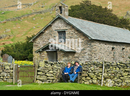 Paar, sitzen vor der alten St. Martin Kirche, Martindale, Nationalpark Lake District, Cumbria, England UK Stockfoto