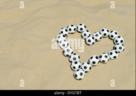 Fußball Liebe Herz gemacht mit Fußball-Kugeln-Nachricht am hellen Sandstrand in Rio De Janeiro Brasilien Stockfoto