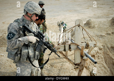 Ein US-Soldat untersucht eine primitive Abreißgerät westlich von Forward Operating Base Ramrod 24. Dezember 2009 in der Provinz Kandahar, Afghanistan. Die Soldaten befürchtete, dass es benutzt wurde, um eine improvisierte Explosion Gerät zu Pflanzen. Stockfoto