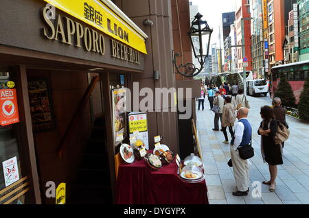 Ginza, Tokio, Japan. 17. April 2014. Gönner zu stoppen um das Menue in Ginza Lion Bier Hall in Tokio zu betrachten. Lion Restaurant feiert 80. Geburtstag in Ginza Japan. Ramiro Agustin © Vargas Tabares/ZUMA Wire/ZUMAPRESS.com/Alamy Live-Nachrichten Stockfoto