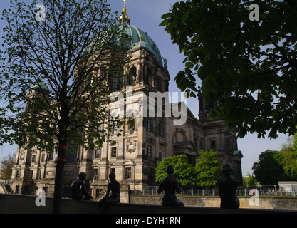 Blauer Himmelsblick auf Berliner Dom, Silhouetten von männlichen und weiblichen Bronzestatuen sitzt an der Wand von der Spree-Promenade, Berlin Stockfoto