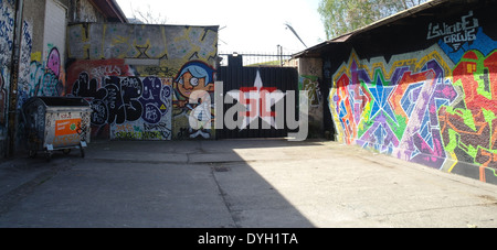 Blauer Himmel Blick Innenhof zwischen den Gebäuden mit Cartoon Bild und Graffiti Gekritzel Farben, Raw Tempel, Revaler Straße 99, Berlin Stockfoto