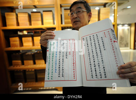 (140418)--YANGZHOU, 18. April 2014 (Xinhua)--Lu Guobin, Manager von Yangzhou Bindungen, zeigt das Duplikat ein klassisches chinesisches Buch, "Siku Quanshu" oder die "vollständige Bibliothek der vier Zweige der Literatur" in Yangzhou, der ostchinesischen Provinz Jiangsu, 17. April 2014. Die Wiedergabe von "Siku Quanshu" wird auf dem Display in der Wanfo-Gebäude am Tianning Tempel von Yangzhou ab 18. April sein. Zusammenstellung von "Siku Quanshu," unter der Herrschaft des Kaisers Qianlong (1736-1795) in der Qing Dynastie (1644-1911) ins Leben gerufen und organisiert von der literarischen Kaiser selbst, dauerte 15 Jahre t Stockfoto