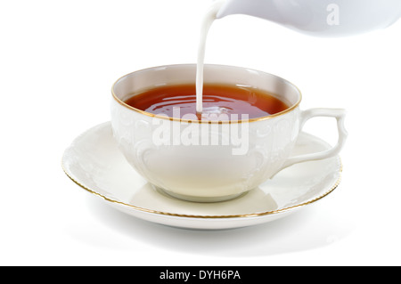 Portion Tee mit Milch isoliert auf weißem Hintergrund. Porzellantasse und Untertasse mit zarten Reliefstrukturen. Stockfoto