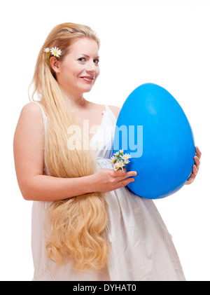 Ostern - junge Frau mit langen blonden Haaren und großen blauen Ei. Stockfoto