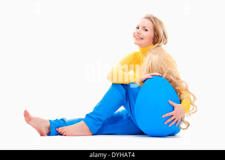 Ostern - junge Frau mit langen blonden Haaren und großen blauen Ei. Stockfoto