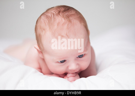 Kleinen Jungen hat eine erholsame Zeit auf seinem weißen Decke Stockfoto