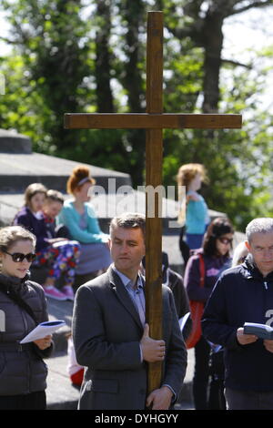 Dublin, Irland. 18. April 2014. Ein Pilger trägt das große Holzkreuz, das die Prozession führt. Der Erzbischof von Dublin, Diarmuid Martin, führte mehrere hundert Pilger in einer "Kreuzweg" Prozession durch Phoenix Park. Die Stationen mit Lesungen, Liedern und Meditation sollte uns der Passion und Kreuzigung Jesu Christi erinnern. Bildnachweis: Michael Debets/Alamy Live-Nachrichten Stockfoto