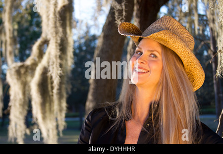 schöne blonde mittlere gealterte Frau Cowgirl mit Cowboy-Hut auf Stockfoto