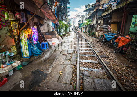 Perspektivische Ansicht der Eisenbahn entlang der engen Gassen mit Häusern in Hanoi, Vietnam. Ungewöhnliche Lösung der Verkehrsprobleme. Stockfoto