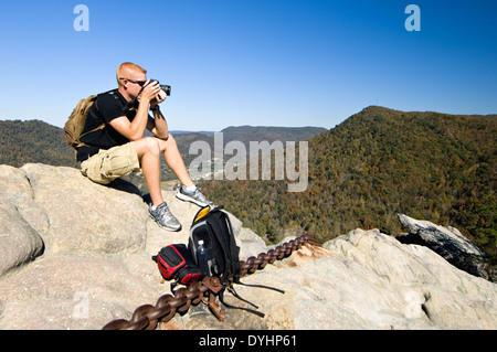 Touristen mit Kamera Sitting on Top of verkettete Rock im Pine Mountain State Park im Bell County Kentucky Stockfoto