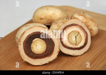 Frische Champignons in Scheiben geschnitten drei Wege auf Holzbrett Stockfoto