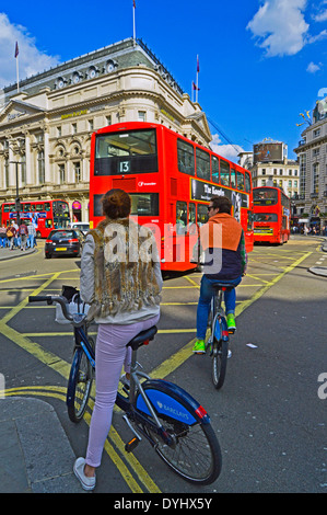 Rote Doppeldeckerbusse und Radfahrer am Piccadilly Circus, West End, London, England, Vereinigtes Königreich Stockfoto