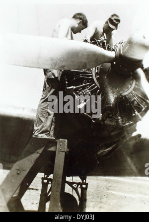 Dieses Bild aus Charles Daniels' Sammlung zeigt eine Motorenüberholung aus dem Zweiten Weltkrieg, wahrscheinlich für Flugzeuge, die im Kampf eingesetzt wurden. Daniels, der während des Krieges aktiv war, hat wichtige Momente der Luftfahrtgeschichte erfasst, darunter die Wartung von Flugzeugen im Pazifik und in Europa. Stockfoto