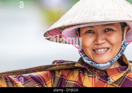 Hoi an, VIETNAM - 4. Dezember: vietnamesische Frau in asiatischen konische Hut lächelnd. 52 % der Bevölkerung arbeiten in der Landwirtschaft. Stockfoto