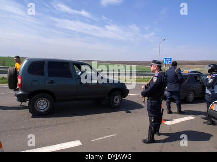 Lugansk, Ukraine. 19. April 2014. Polliceman auf Verordnung Verkehrsknotenpunkt---In Lugansk angespannt. Stadt umgeben Verkehrsregelung Punkt. Polizei, bewaffnete Kalaschnikow überprüfen Sie sorgfältig jeden PKW und LKW. Fahrer und Beifahrer werden zu diesem Verständnis behandelt. Bildnachweis: Igor Golovnov/Alamy Live-Nachrichten Stockfoto