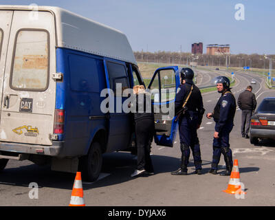 Lugansk, Ukraine. 19. April 2014. Polliceman auf Verordnung Verkehrsknotenpunkt---In Lugansk angespannt. Stadt umgeben Verkehrsregelung Punkt. Polizei, bewaffnete Kalaschnikow überprüfen Sie sorgfältig jeden PKW und LKW. Fahrer und Beifahrer werden zu diesem Verständnis behandelt. Bildnachweis: Igor Golovnov/Alamy Live-Nachrichten Stockfoto