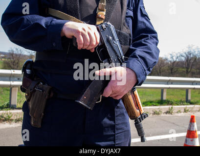 Lugansk, Ukraine. 19. April 2014. Polliceman auf Verordnung Verkehrsknotenpunkt---In Lugansk angespannt. Stadt umgeben Verkehrsregelung Punkt. Polizei, bewaffnete Kalaschnikow überprüfen Sie sorgfältig jeden PKW und LKW. Fahrer und Beifahrer werden zu diesem Verständnis behandelt. Bildnachweis: Igor Golovnov/Alamy Live-Nachrichten Stockfoto