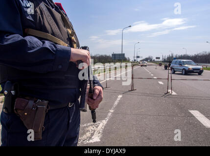 Lugansk, Ukraine. 19. April 2014. Polliceman auf Verordnung Verkehrsknotenpunkt---In Lugansk angespannt. Stadt umgeben Verkehrsregelung Punkt. Polizei, bewaffnete Kalaschnikow überprüfen Sie sorgfältig jeden PKW und LKW. Fahrer und Beifahrer werden zu diesem Verständnis behandelt. Bildnachweis: Igor Golovnov/Alamy Live-Nachrichten Stockfoto