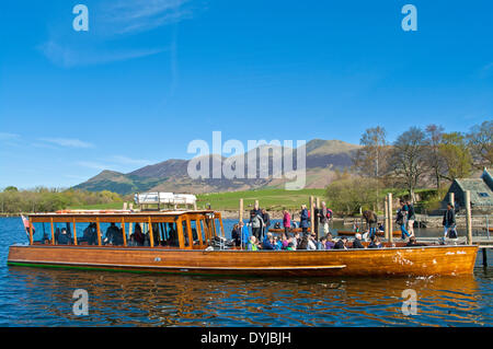 Derwentwater, Keswick, Cumbria, UK. 19. April 2014. Urlauber an Bord die Einführung Annie Mellor für eine Kreuzfahrt rund um Derwentwater, Schafe grasen auf der Wiese hinter, wobei die Skiddaw-Massivs, frei von Cloud, hebt sich deutlich gegen den blauen Himmel. Bildnachweis: Julie Fryer/Alamy Live-Nachrichten Stockfoto