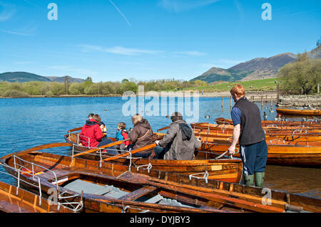 Derwentwater, Keswick, Cumbria, UK. 19. April 2014. Eine Gruppe von sechs Urlauber, darunter zwei kleine Kinder tragen von Schwimmwesten, bereiten Sie sich ein Ruderboot auf Derwentwater, nehmen als der Bootsmann bereitet, das Boot in den See heraus zu drücken. Bildnachweis: Julie Fryer/Alamy Live-Nachrichten Stockfoto