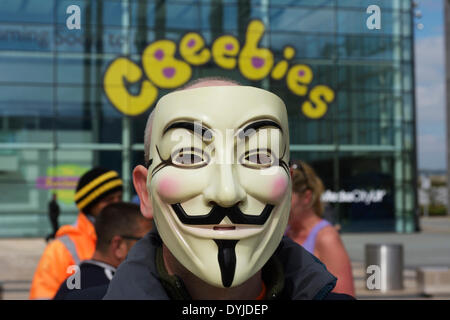 MANCHESTER, UK Samstag 19.. April 2014. Demonstrant mit 'Anonymous' Maske stand vor BBC-Studios in der Media City in Manchester bei einem Protest gegen die BBC, die die Demonstranten zu voreingenommen und beschädigt werden. Bildnachweis: Dave Ellison/Alamy Live-Nachrichten Stockfoto