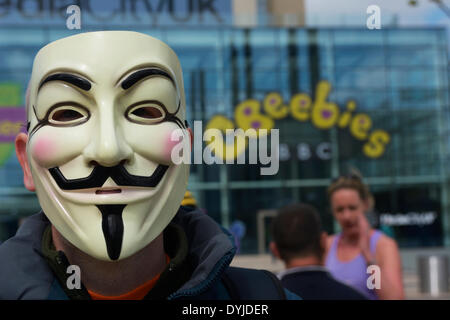 MANCHESTER, UK Samstag 19.. April 2014. Demonstrant mit 'Anonymous' Maske steht vor den BBC-Studios in der Media City, Salford Quays während einer Protestaktion gegen die Mainstream-Medien, die ihrer Meinung nach zu voreingenommen sein und beschädigt werden. Bildnachweis: Dave Ellison/Alamy Live-Nachrichten Stockfoto