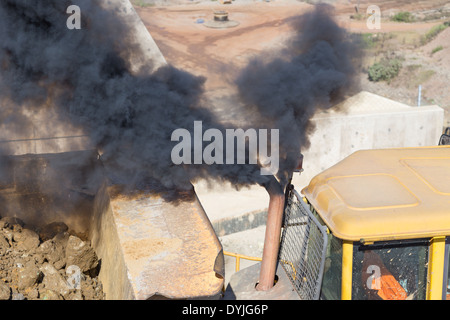 Ein Auspuffrohr aus einem Muldenkipper rülpst Rauch in einem großen Tagebau Grube in Sambia, Afrika Stockfoto