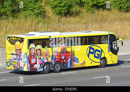 Werbegrafiken für Abenteuerreisen für Schulkinder auf der Seite und Rückseite des Reisebusses auf der Autobahn M25 Essex England UK Stockfoto