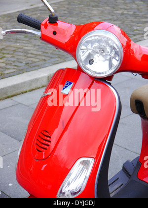 Abstrakte Teilansicht des roten Piaggio Vespa-Roller auf einer Stadtstraße Stockfoto