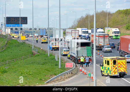 Polizei auf was wird geglaubt, zu 2 getrennte Ereignisse einer fernen & LKW Inhalt überprüft mit Menschen sitzen auf Leitplanke Stockfoto