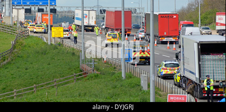 Polizei auf was geglaubt wird, um 2 Vorfälle einer fernen & LKW Inhalt überprüft mit Menschen sitzen auf Leitplanke Stockfoto