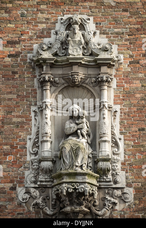 BRÜGGE, Belgien - Eine Statue der Madonna und des Kindes an der Außenseite des Glockenturms am Markt (Marktplatz) im historischen Zentrum von Brügge, das zum UNESCO-Weltkulturerbe gehört. Mittelalterliche Architektur und ruhige Kanäle prägen das Stadtbild von Brügge, oft als „Venedig des Nordens“ bezeichnet. Brügge gehört zum UNESCO-Weltkulturerbe und bietet Besuchern eine Reise in die Vergangenheit Europas mit seinen gut erhaltenen Gebäuden und kopfsteingepflasterten Straßen, die die reiche Geschichte der Stadt widerspiegeln. Stockfoto