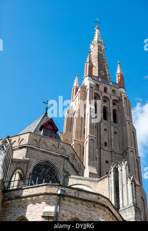 BRÜGGE, Belgien – der hoch aufragende gotische Turm der Marienkirche (Onze-Lieve-Vrouwekerk) dominiert die mittelalterliche Skyline von Brügge. Dieses architektonische Meisterwerk erhebt sich deutlich über dem historischen Zentrum und ist eines der bekanntesten Wahrzeichen der Stadt. Der Turm ist ein Beispiel für die anspruchsvolle Technik und künstlerische Leistung der mittelalterlichen gotischen Architektur. Stockfoto