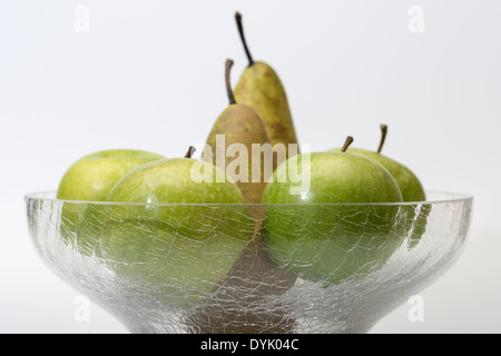 Äpfel und Birnen in Glasschale isoliert auf weiss mit Textfreiraum Stockfoto