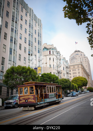 California Street Cable Car rumpelt, Nob Hill in San Francisco, Kalifornien. InterContinental Mark Hopkins Hotel auf der rechten Seite. Stockfoto