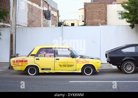 Gelbes Auto mit Platte Reifen und viele Anzeigen in Lima, Peru Stockfoto