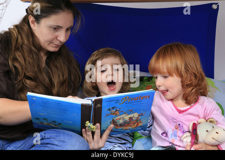 Mutter ein Buch über Piraten zu ihren Kindern in ein Billi-Bolli Hochbett Stockfoto