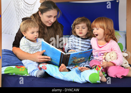 Mutter ein Buch über Piraten zu ihren Kindern in ein Billi-Bolli Hochbett, Stockfoto