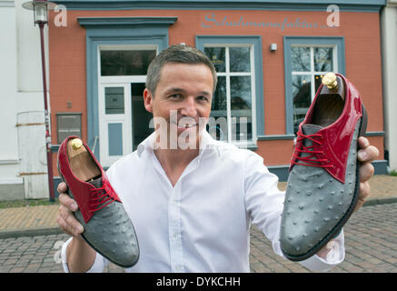 Parchim, Deutschland. 7. April 2014. Schuhmacher Kay Gundlack hält ein paar maßgeschneiderte Schuhe in seine Schuhfabrik in Parchim, Deutschland, 7. April 2014. Etwa dreißig Stunden Arbeit dauert es um ein paar Schuhe zu fertigen. Der Schuhmacher fertigt Schuhe für prominente Musiker und Schausteller oder Geschäftsleute seit 2005. Foto: Jens Büttner/Dpa/Alamy Live News Stockfoto