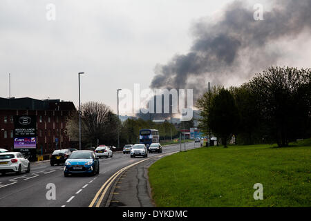 Leeds, West Yorkshire, UK, 21. April 2014. Verkehr auf der A647 Armley Straße. Ein Pall von Rauch in der Luft hängt, wie Feuerwehrleute einen Großbrand in einem Gewerbegebiet Leeds anzugehen. Das Feuer brach bei ca. 01:50 in den Räumlichkeiten des Tradpak eine Chemikalie Verpackung und recycling-Anlage im Bereich Armley der Stadt. Die Fabrik liegt in der Nähe des Stadtzentrums und Anwohner aufgefordert ihre Fenster und Türen geschlossen, weil der potenziell toxischen Chemikalien beteiligt zu halten. Bildnachweis: Ian Wray/Alamy Live-Nachrichten Stockfoto