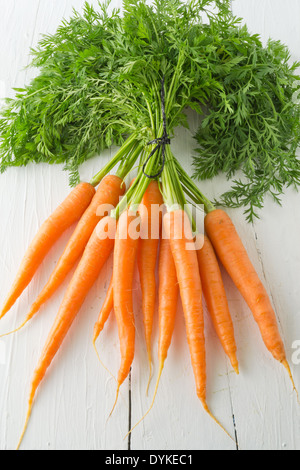 Ein paar Möhren auf einen weißen Tisch angezeigt. Eine beliebte Wurzel Gemüse voller Vitamin a. Stockfoto